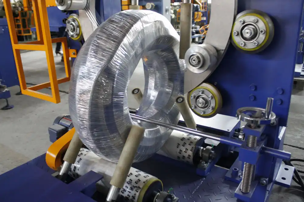 Vertical stretch wrapper applying film to a coil placed on a turntable