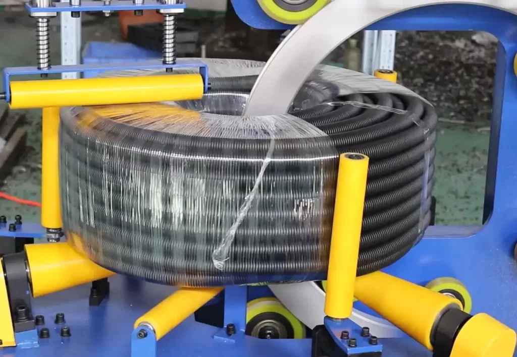 Horizontal orbital stretch wrapping machine securing long corrugated pipes with film