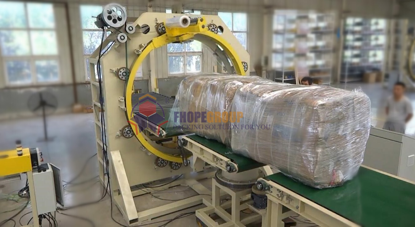 Automated cross wrapping machine in operation Fully automated orbital stretch wrapper integrated into a conveyor line, demonstrating efficient pallet cross-wrapping.