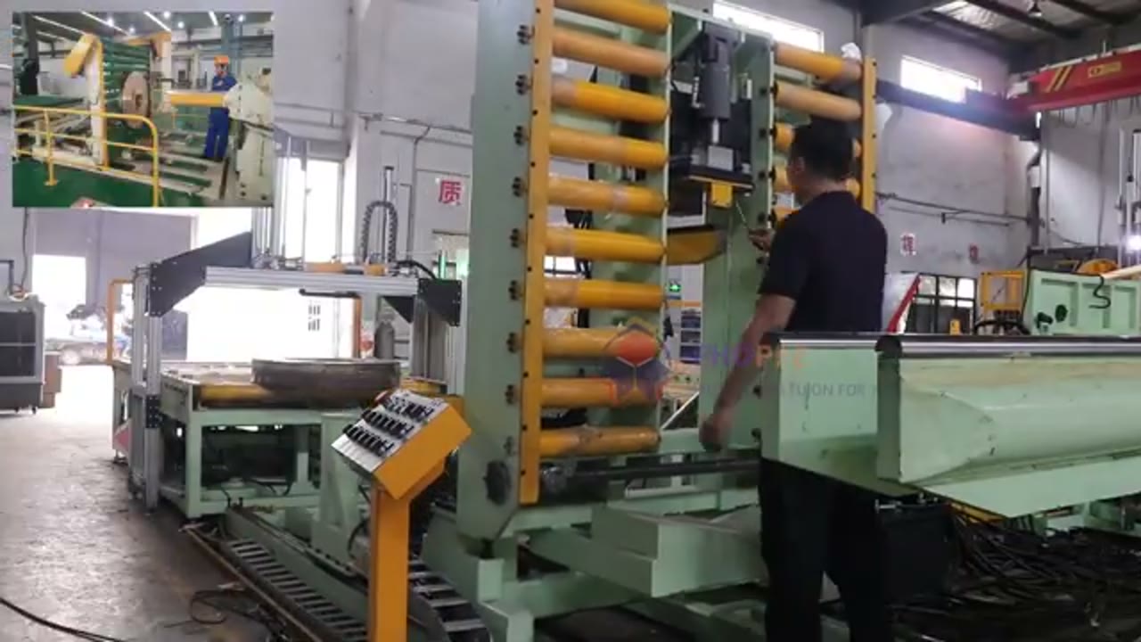 Vertical coil handling station with a roller structure and control panels, and an inset view of a coil held near vertical with an operator