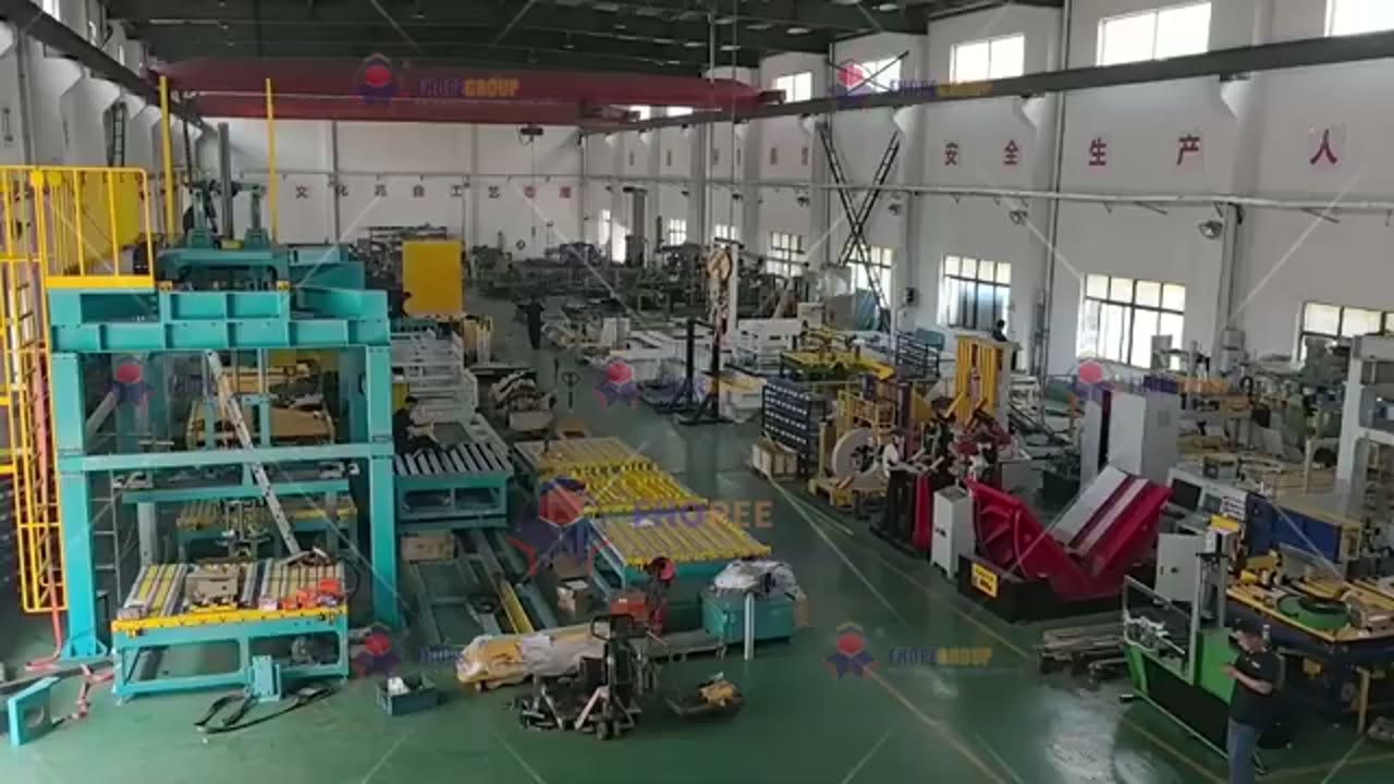 Factory hall at the start of the reviewed clip, showing coil handling and wrapping equipment on a conveyor line
