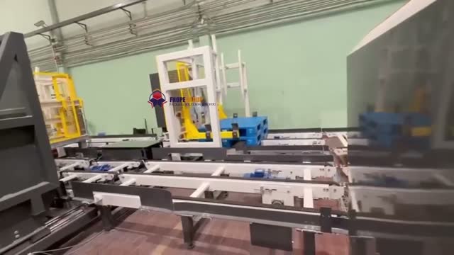 A palletized stack that has just been rotated ninety degrees on a yellow turntable