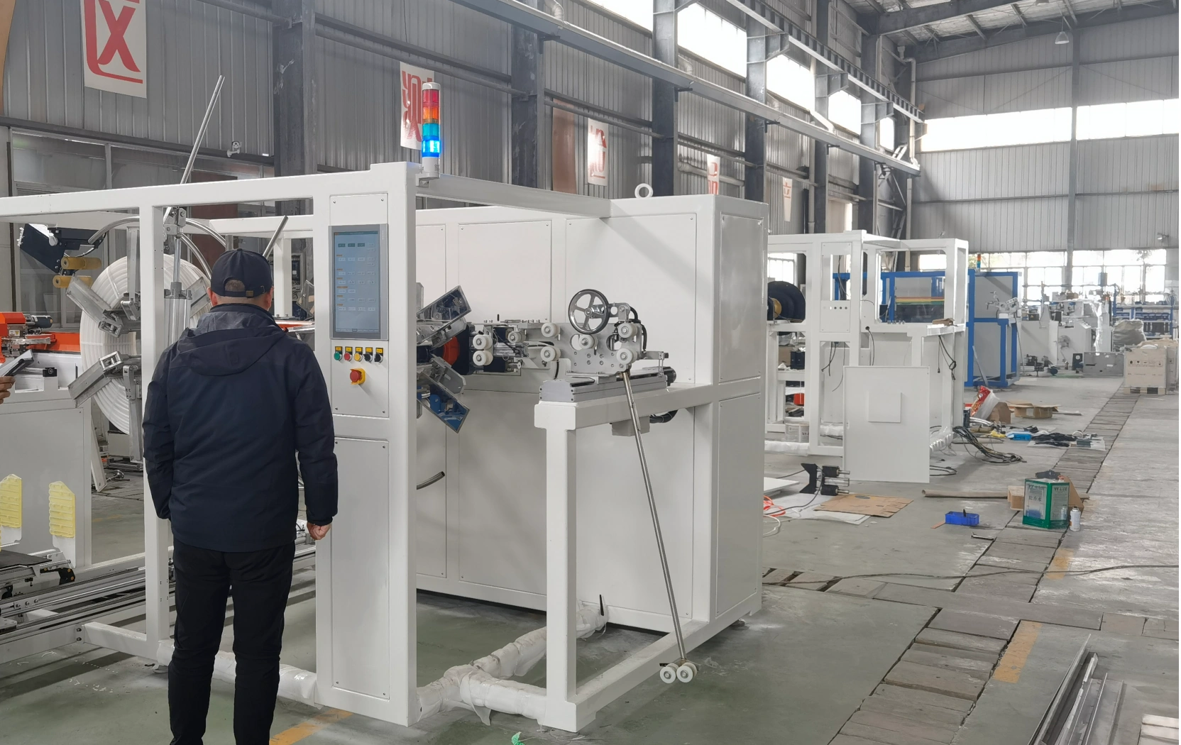 A pipe and hose coiling and wrapping machine with a coil carried on its mandrel between guide rollers